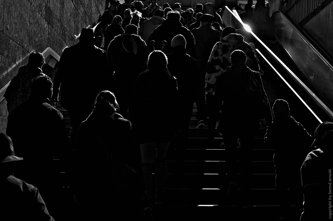 Menschenmassen auf einer Rolltreppe – Trügerisches Spiel im Kölner Karneval – Mimesis Mimesis – Trügerisches Spiel im Karneval – Menschenmassen auf einer Rolltreppe