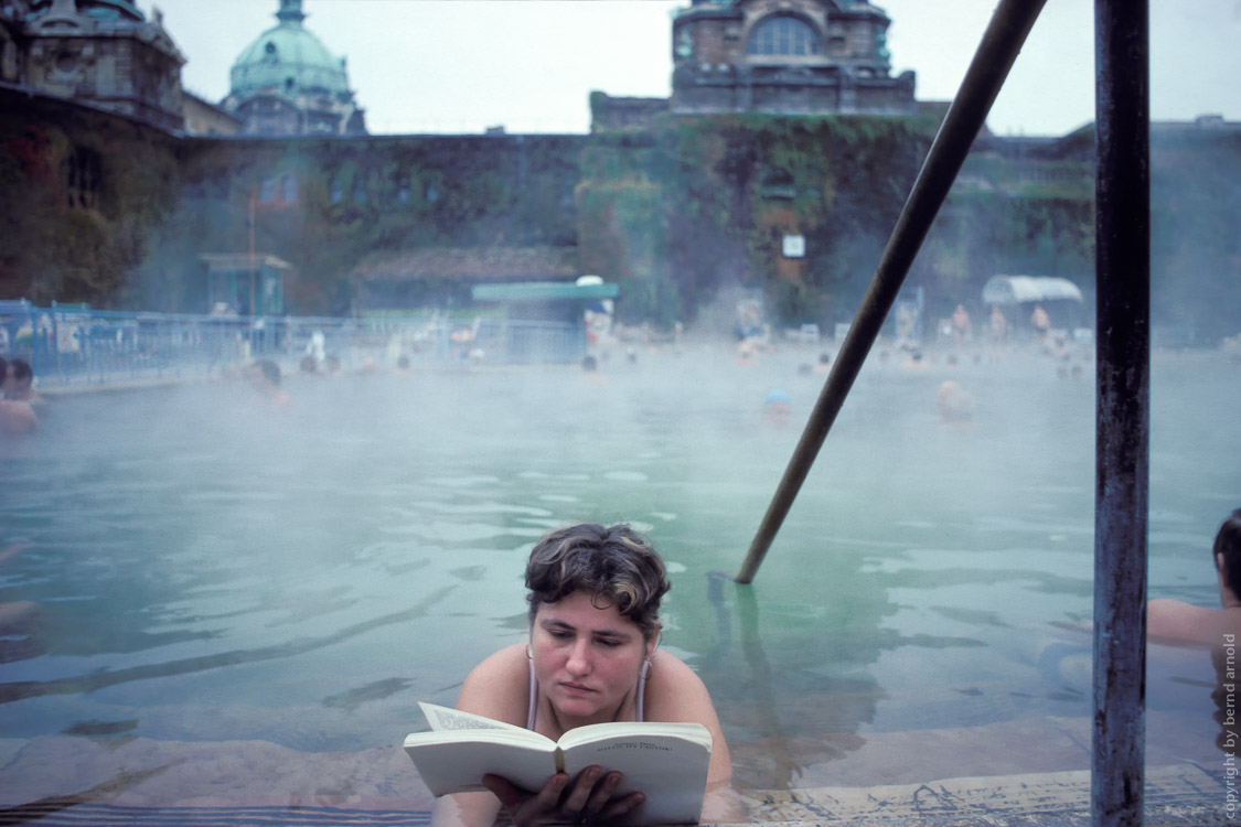 Frau liest entspannt ein Buch im Wasser – Szechenyi Bad in Budapest, Ungarn