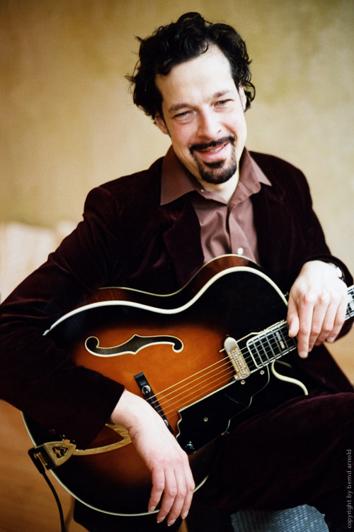 Portraitfotografie – Frank Wingold (lachend) mit Jazz-Gitarre
