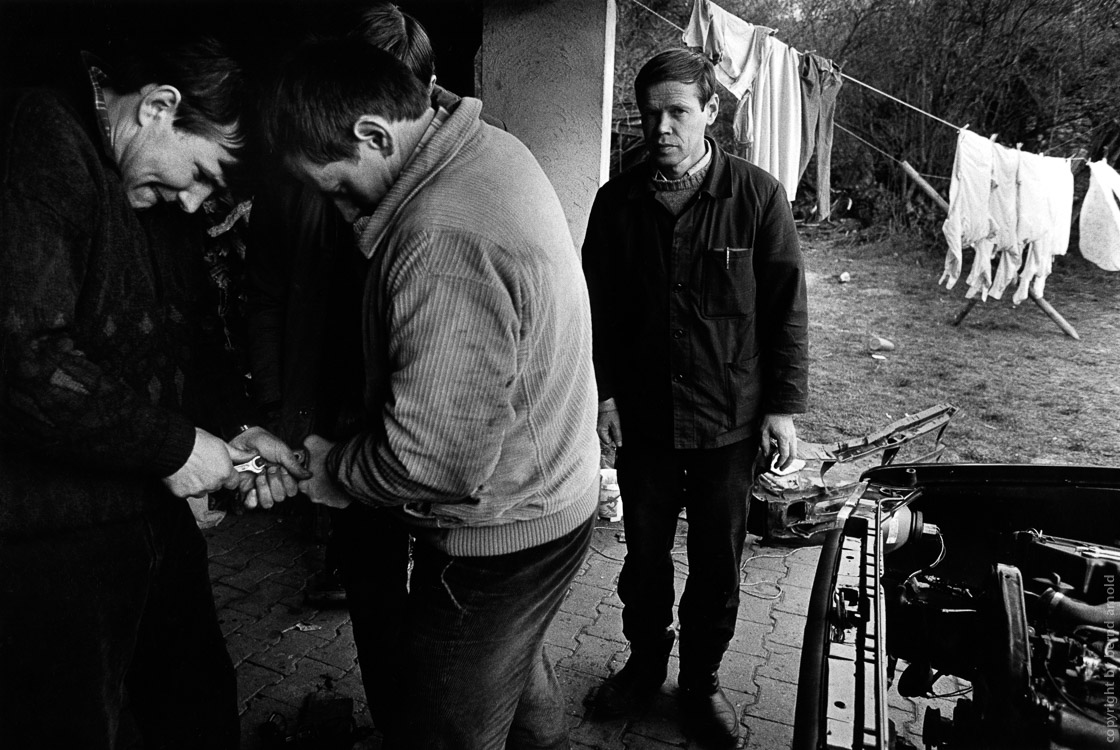 immigrants repair a car 